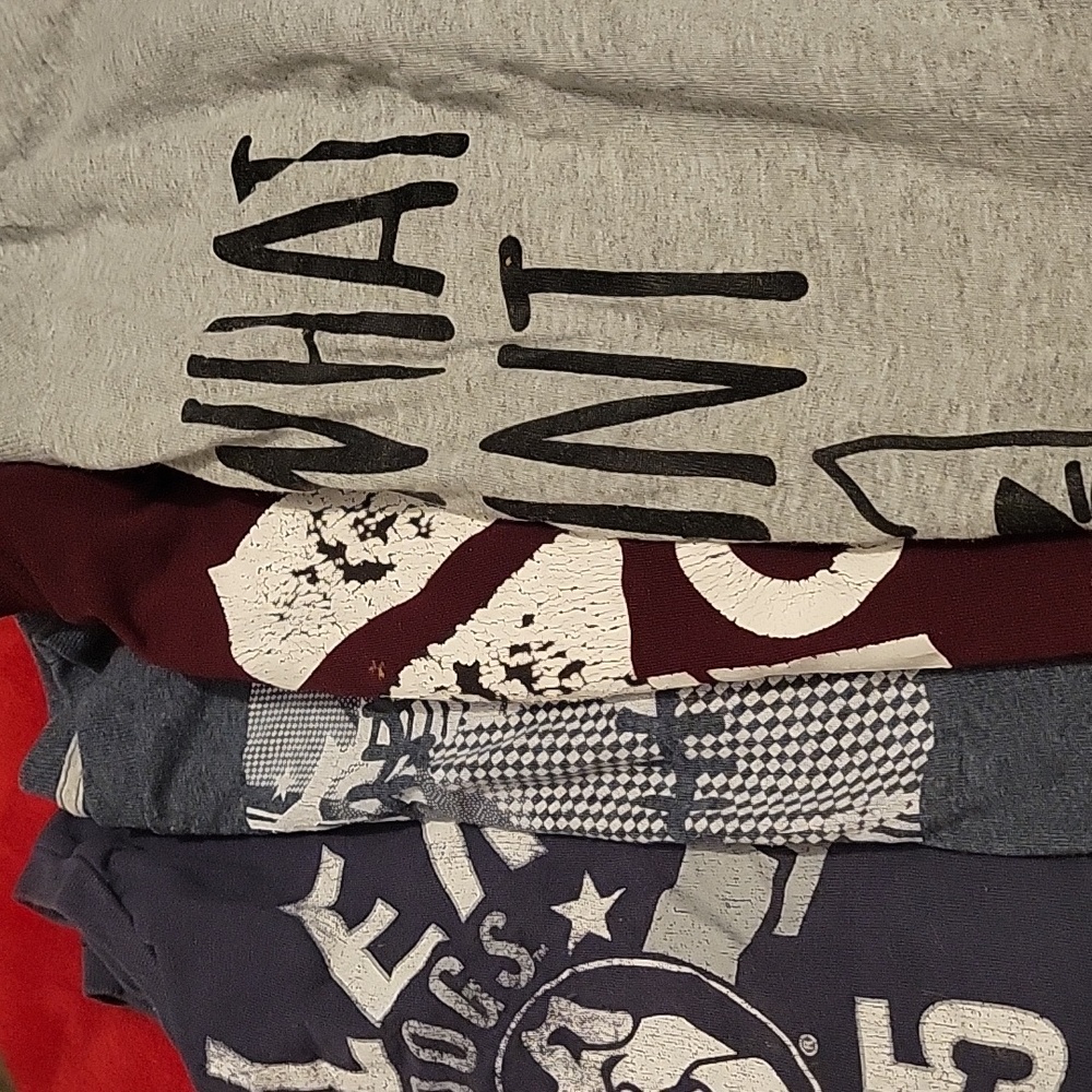 Four different sizes t shirts for boys ranging from size ten twelve to fourteen